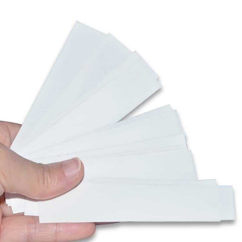 Hand holding a piece of white paper with a cutout shape on a white background