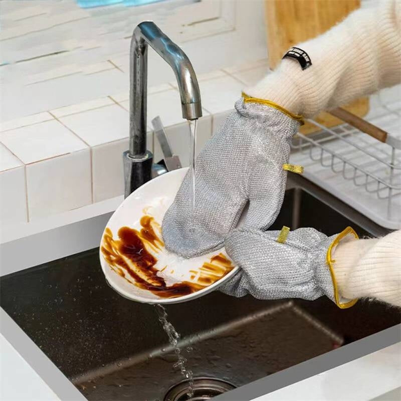Person wearing cut-resistant gloves washing a dirty plate in a kitchen sink.