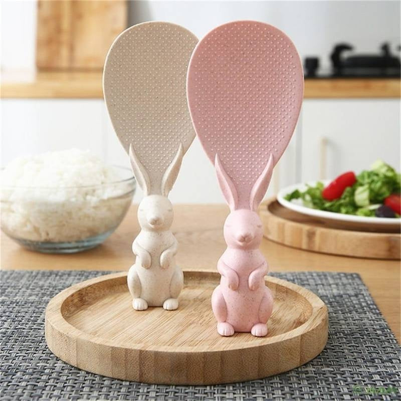 Two rabbit-shaped spoons on a wooden stand with a kitchen background