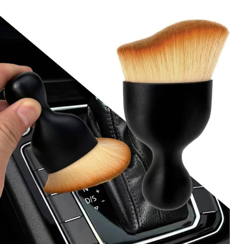 Makeup brushes with black handles and wooden bristles on a car gear shift.