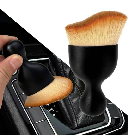 Makeup brushes with black handles and wooden bristles on a car gear shift.