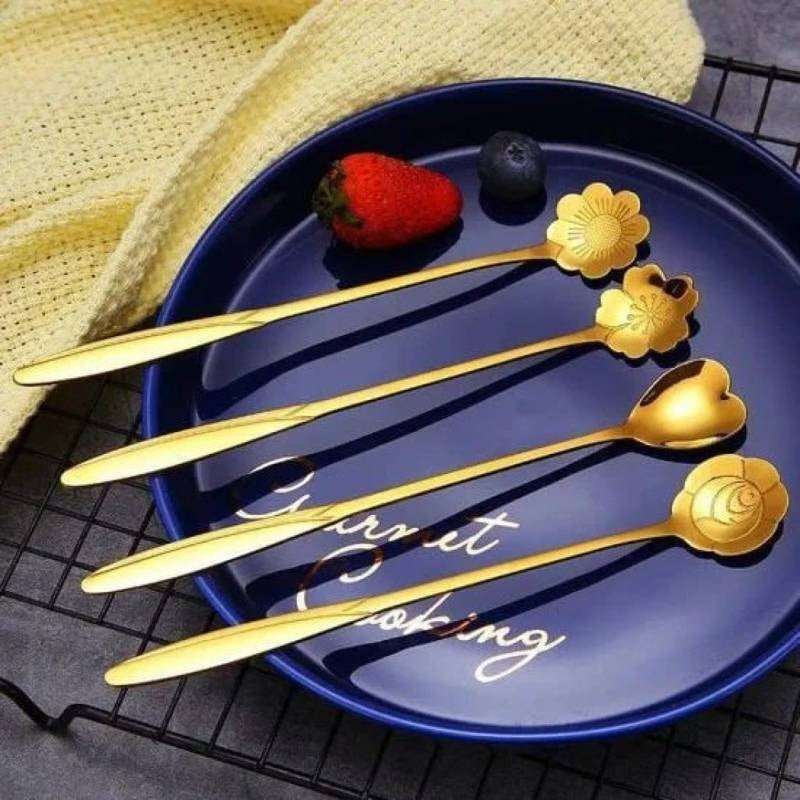 Set of gold floral spoons on a blue plate with 'Here it is' text