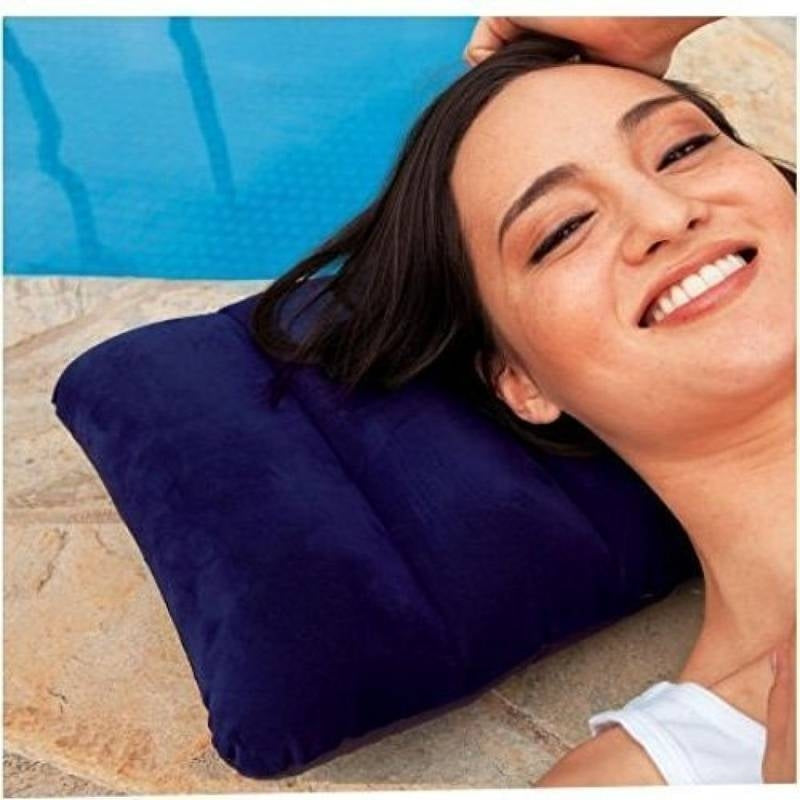 Woman lying on a blue inflatable pillow by a pool