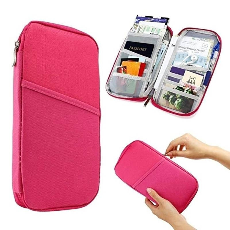 Pink travel organizer with compartments for documents and cards on a white background