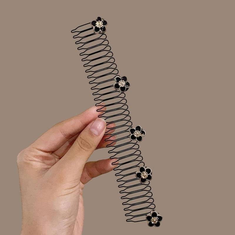 Hair comb with decorative flowers held by a hand on a beige background