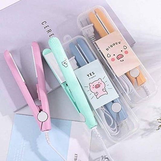 Set of small hair straighteners with cute designs in a clear case on a light background