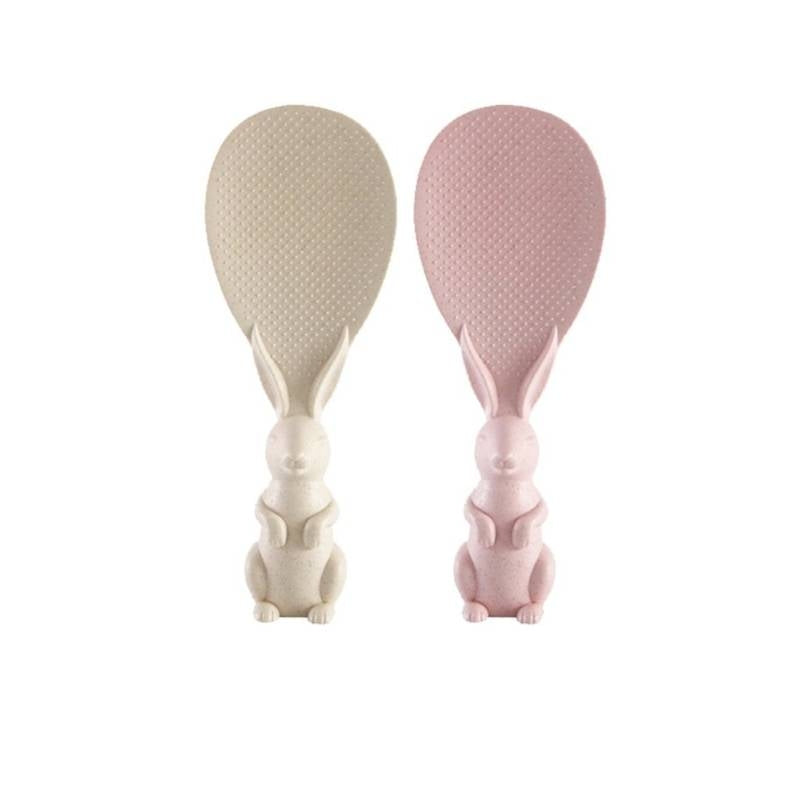 Two rabbit-shaped spoon rests, one beige and one pink, on a white background.