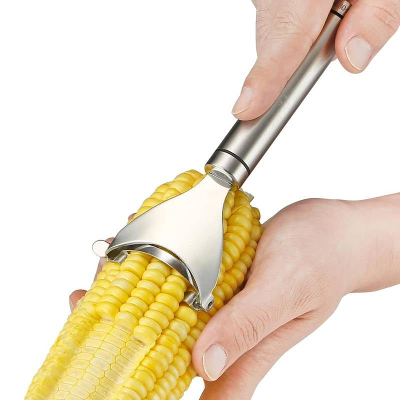 Corn shucker being used to remove kernels from a cob with a white background