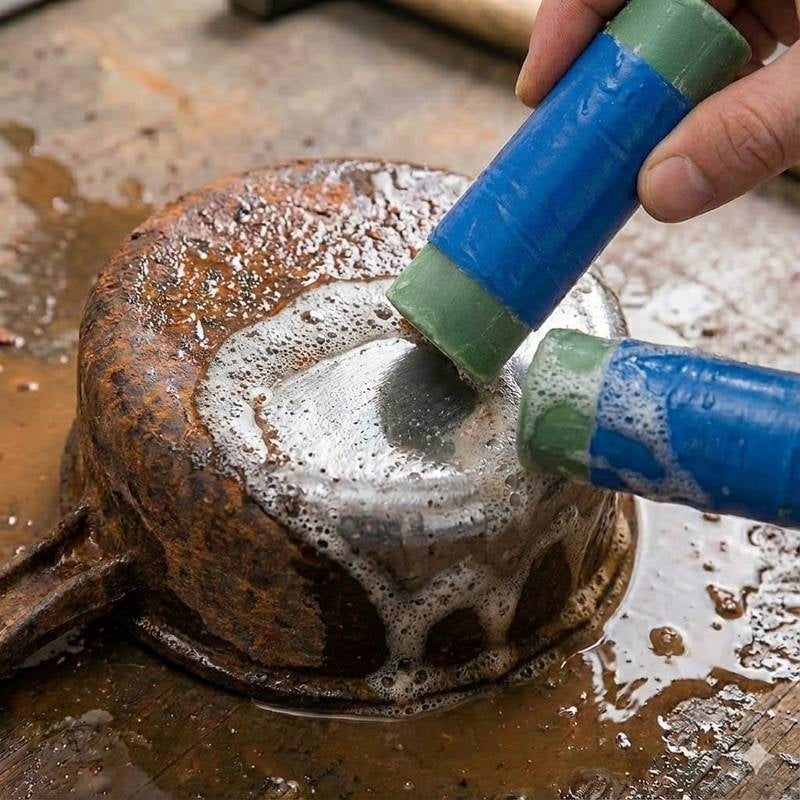 Person cleaning a rusty metal object with a blue and green brush.