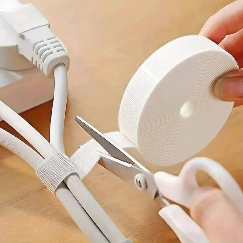 Person cutting white cable ties with scissors on a wooden surface