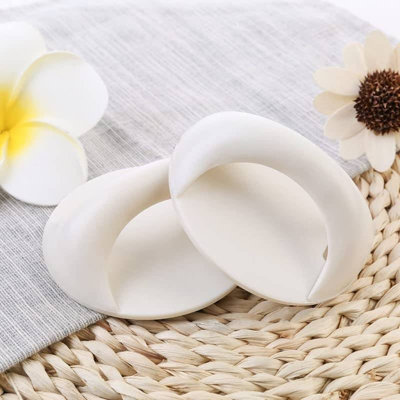 White silicone breast pads on a textured surface with flowers