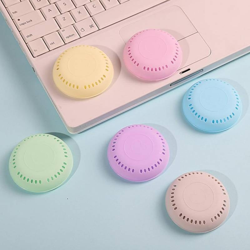 Pastel-colored round keycaps on a light blue surface with a laptop keyboard in the background.