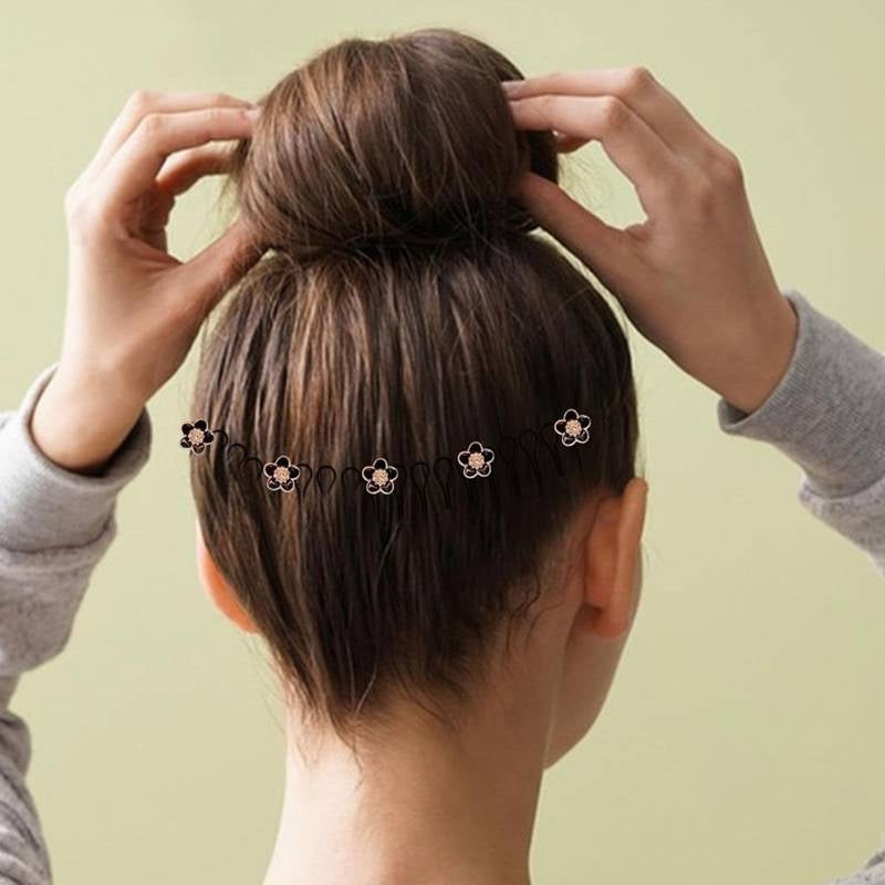 Person styling hair with hair ties against a light green background