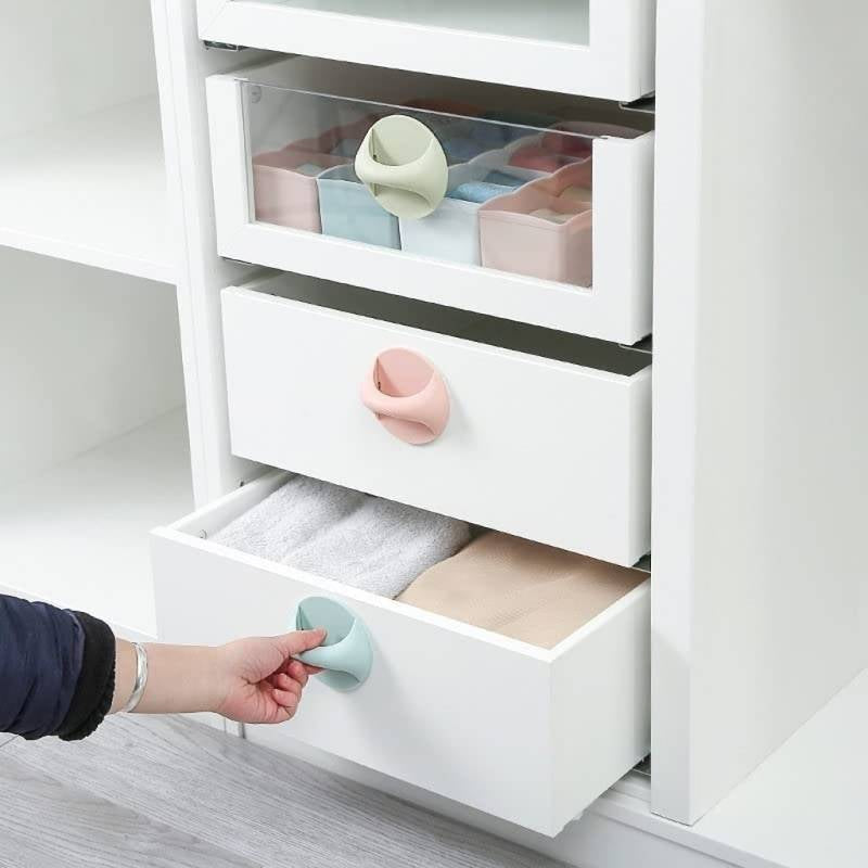 White dresser with open drawers featuring colorful soft baby handles.