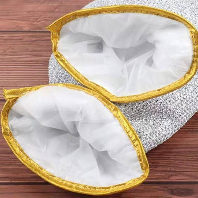 Metallic scrubber with white mesh and gold trim on a wooden surface