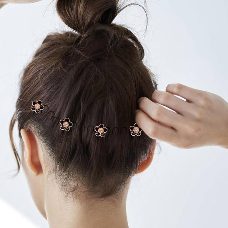 Woman with hair tied up wearing decorative hairpins on a white background